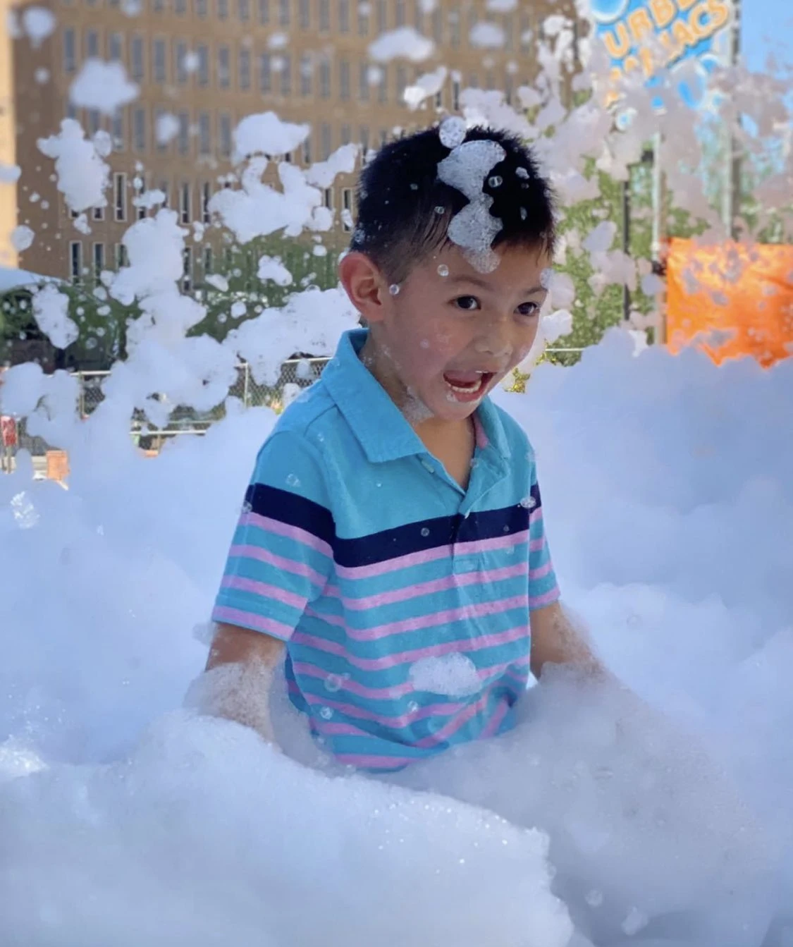 Kid surrounded by bubbles and foam
